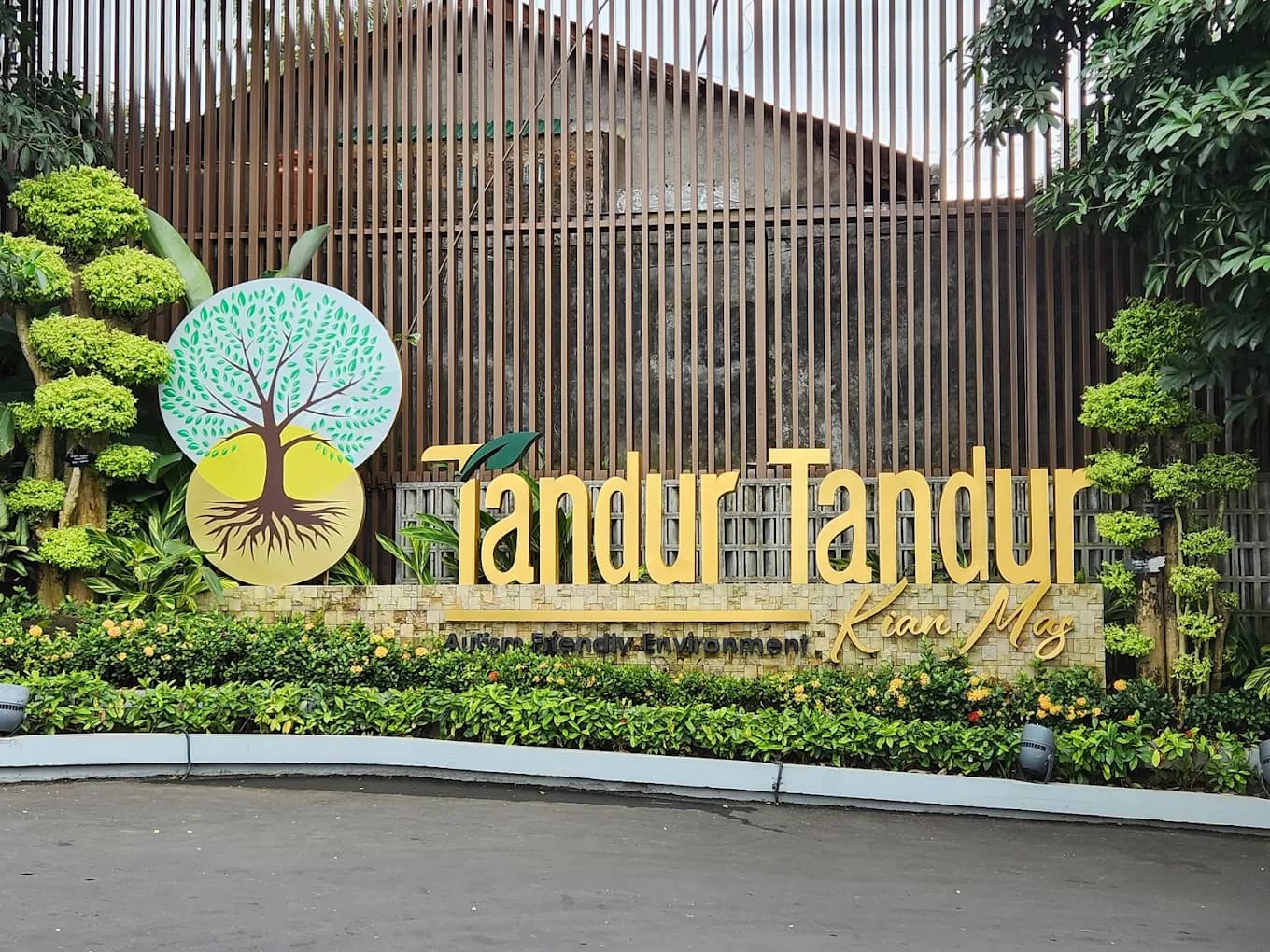 Tandur Tandur Kian Mas entrance sign surrounded by landscape plants