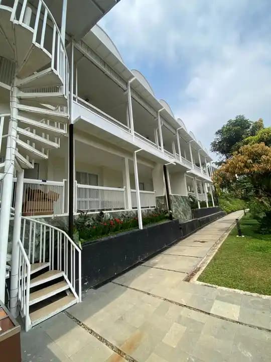 White resort exterior beside a landscaped garden path
