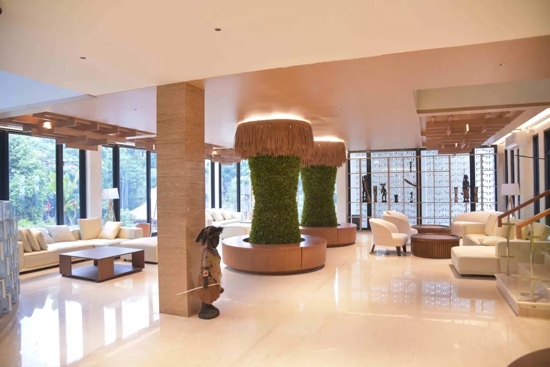 Bright Kian Mas lobby with sculptural green columns and warm wood finishes